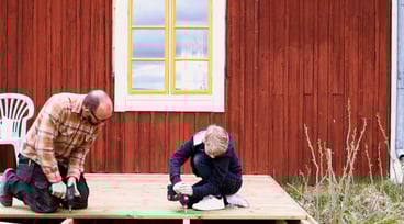 Pappa och son skruvar på ett trädäck