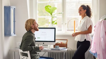 En man och en kvinna samtalar vid en datorskärm