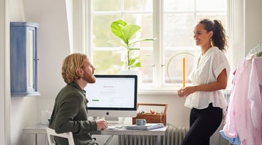 Kvinna och man samtalar vid en dator