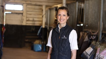 Karin Westman står i ett stall