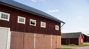 En röd byggnad på en lantbruksfastighet