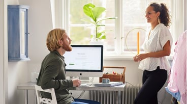 Man och kvinna som pratar vid en dator i hemmet