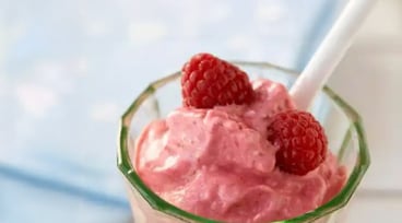 Rosa glass med hallon på toppen