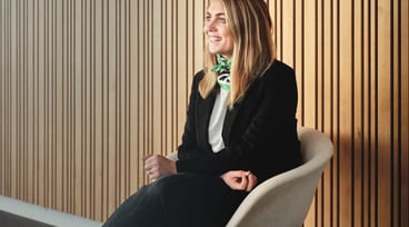 Evelina Gunnarsson sitter på en stol intill en vägg