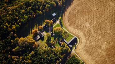 Flygfoto över lantbruk med åker