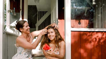 Kvinna och hennes dotter sitter på trappan utanför ett hus