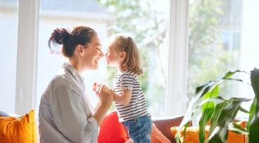 En mamma och en dotter sitter i en soffa