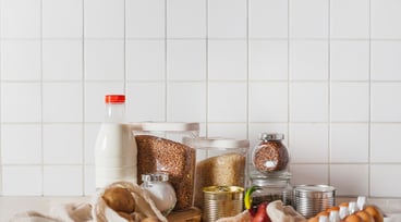 Ägg, mjölk och konservburkar uppställda på ett bord