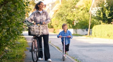 Kvinna och pojke på promenad i villakvarter.