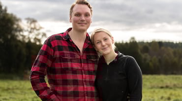 Sara och Carl-Johan står framför ett fält.