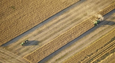 Vy över skördetröska på åker.