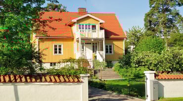 Gul villa med grönskande trädgård
