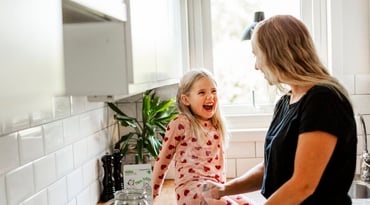 En flicka med sin mamma i köket