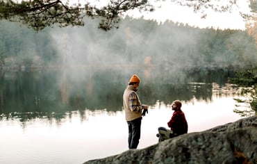Två män pratar med varandra vid kanten av en sjö