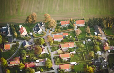 Flygfoto över villakvarter bredvid åker