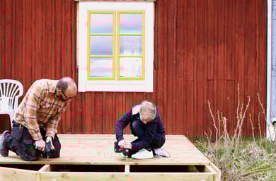 Man och pojke borrar på en träaltan