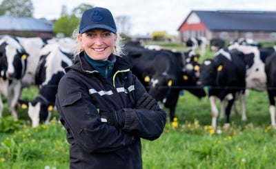 Hanna Karlsson står framför en grupp kor i hagen.