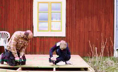 Pappa och son skruvar på ett trädäck