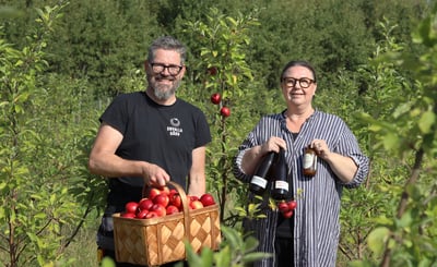 Carl och Anna-Karin står bland sina nyplanterade äppelträd