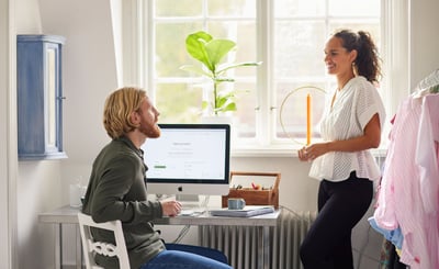 En man och en kvinna samtalar vid en datorskärm