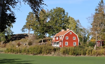 Stort rött hus i landsmiljö.