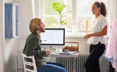 Man och kvinna som pratar vid en dator i hemmet