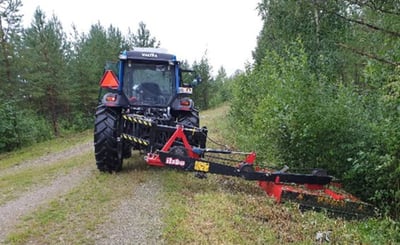 Maskin kör längs skogsväg och röjer i diket