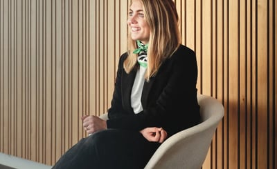 Evelina Gunnarsson sitter på en stol intill en vägg