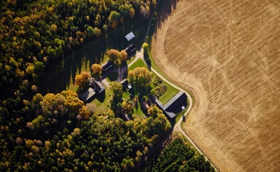 Flygfoto över lantbruk med åker