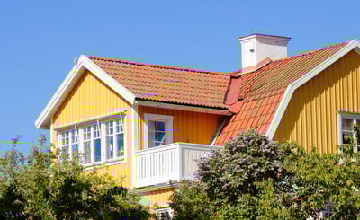 Övre delen av en gul villa mot blå himmel