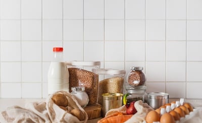 Ägg, mjölk och konservburkar uppställda på ett bord