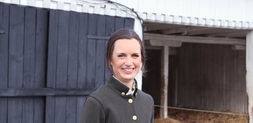 Karin står framför en ladugårdsbyggnad.