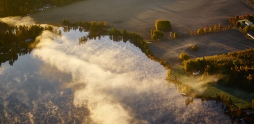 Flygbild över sjö och åkerlandskap