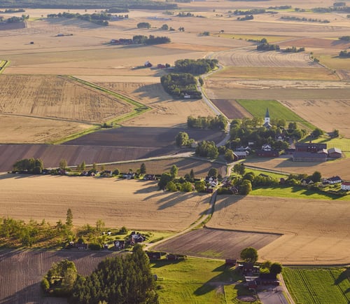 Flygfoto över landskap med åkrar och kyrka