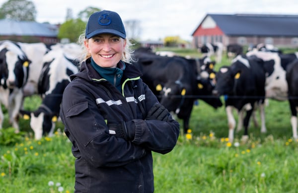 Hanna Karlsson står framför en grupp kor i hagen.