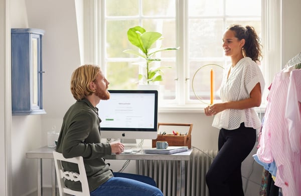 En man och en kvinna samtalar vid en datorskärm