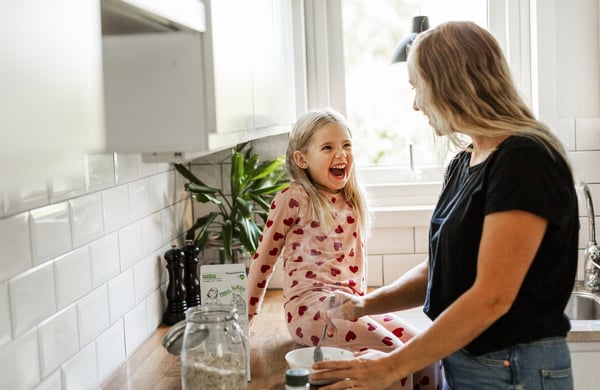 Flicka och mamma i en kök