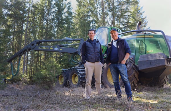 Staffan och Martin står framför en skogsmaskin