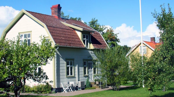 Vit villa med trädgård i förgrunden