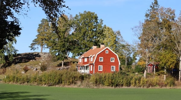 Stort rött hus i landsmiljö.