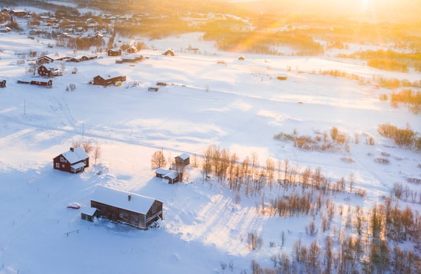 Vy över vinterlandskap, hus och träd