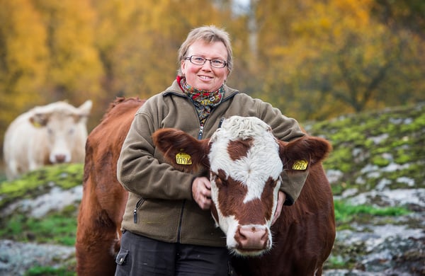 Karin Andersson håller om en ko