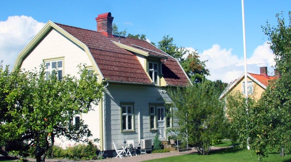 Vit villa med trädgård i förgrunden