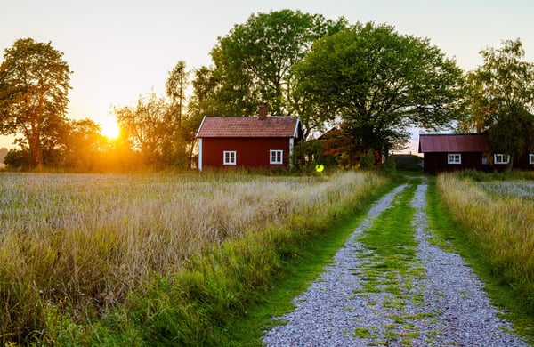 Två röda hus på landet med solnedgång