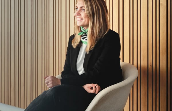 Evelina Gunnarsson sitter på en stol intill en vägg