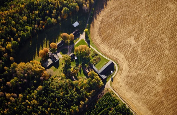 Flygfoto över lantbruk med åker