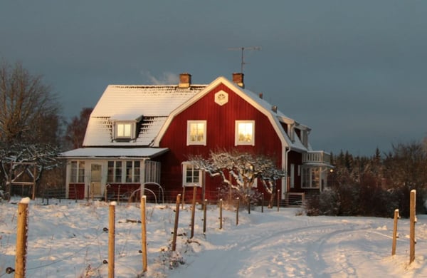 Rött hus vid vintrig landsväg