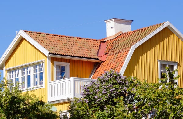 Övre delen av en gul villa mot blå himmel