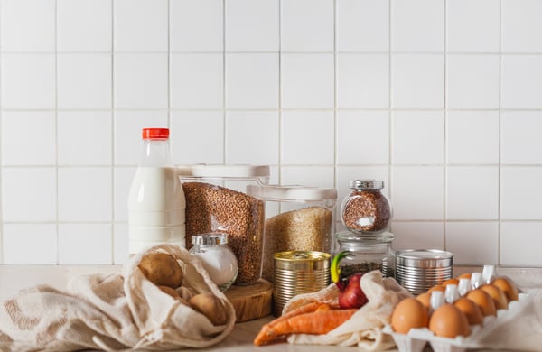 Ägg, mjölk och konservburkar uppställda på ett bord