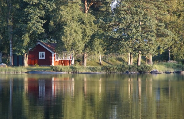 Röd stuga vid vattnet